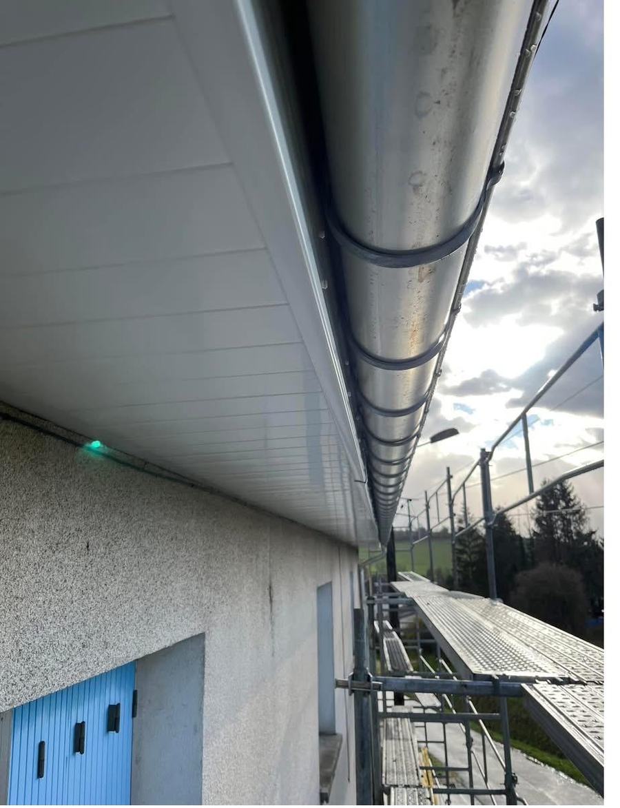 Gouttière demi-ronde en zinc et sous-face de débord de toit en lames blanches